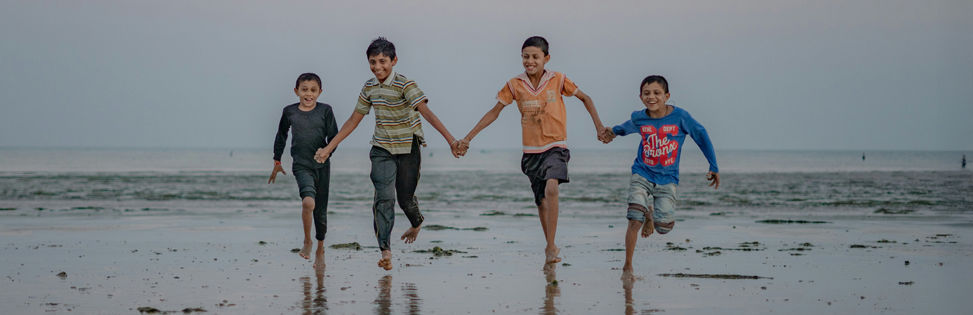 boys running in sand on beach