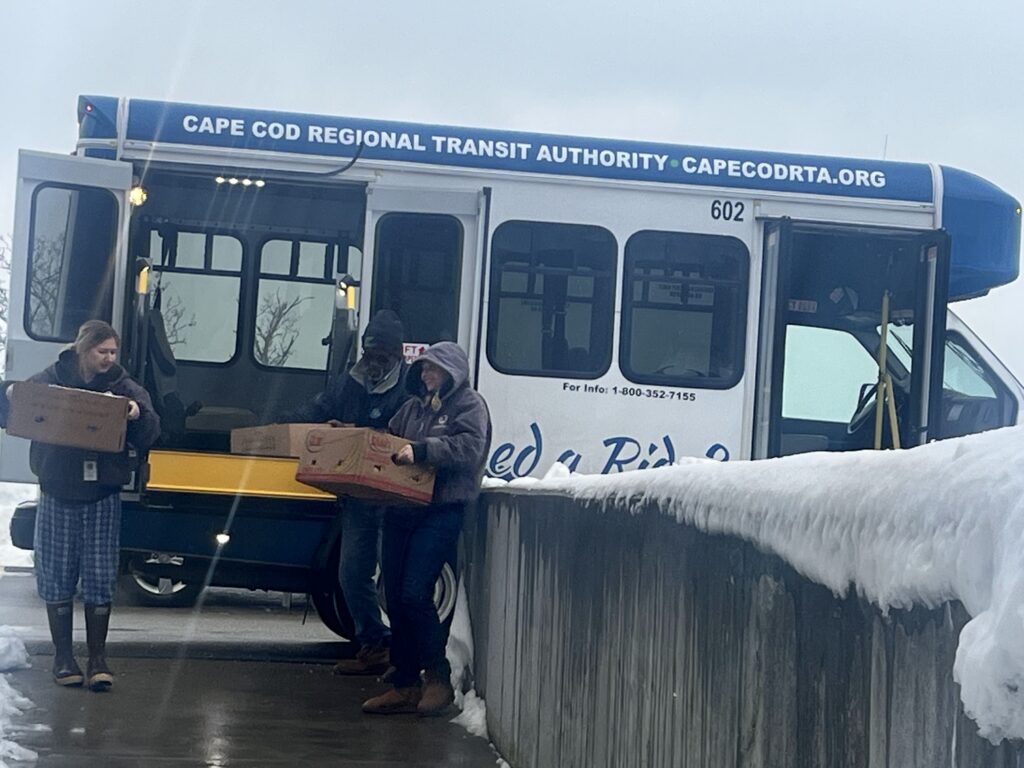 ACC members unload boxes of food from a bus.