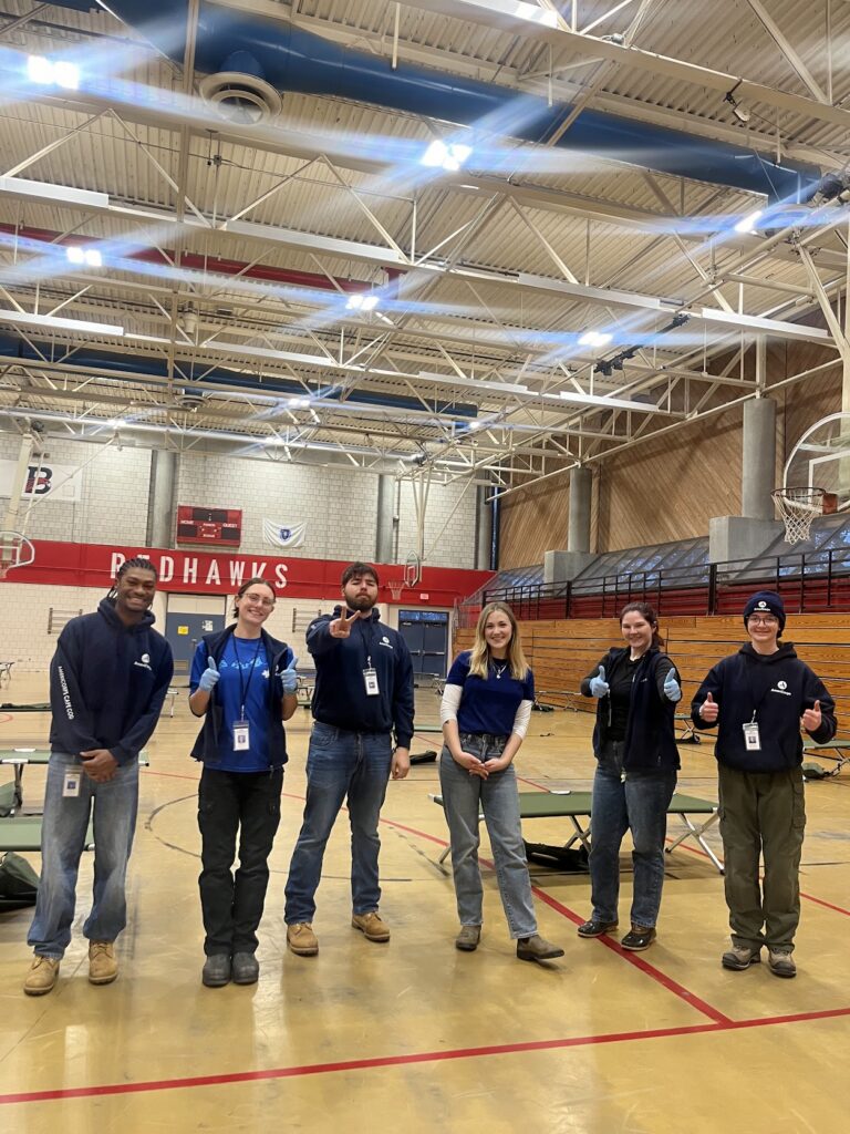 ACC members and staff stand in a school gymnasium that will be a winter storm shelter.