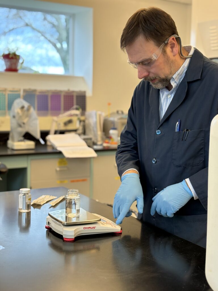 Dan White preparing a labeled water sample for analysis on a laboratory scale at the Barnstable County Water Quality Laboratory.
