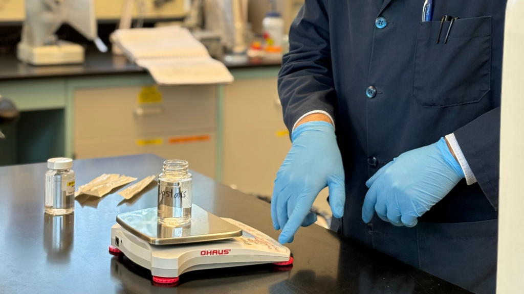 Dan White preparing a labeled water sample for analysis on a laboratory scale at the Barnstable County Water Quality Laboratory.